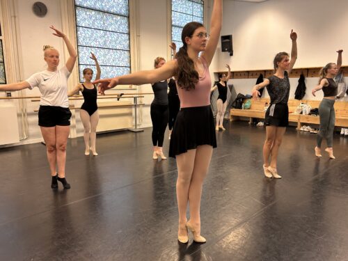 verschillende vrouwen die in een danszaal staan om ballet te oefenen