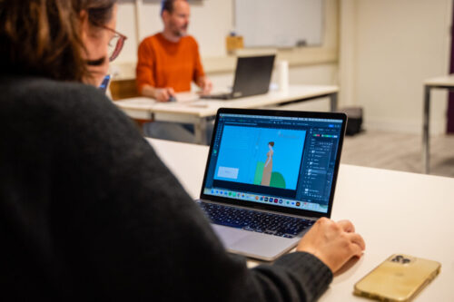 een persoon die achter een laptop een animatie zit te editen