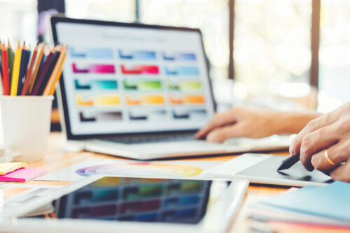 iemand die aan grafisch vormgeving doet en achter de laptop zit